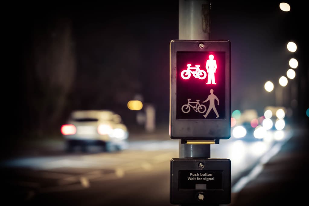 A red crossing signal holds traffic until it is safe to proceed: every change waits at the policy gate until checks pass. Photo: "Macro Experiments - The Crossing" (Flickr), CC0 public domain.